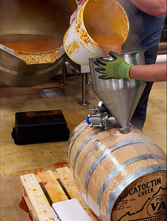 pouring from industrial vat into barrel
