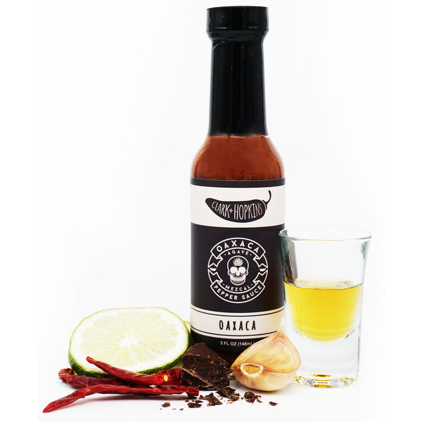 OAXACA front bottle dark chocolate chili peppers garlic clove lime shotglass with mezcal